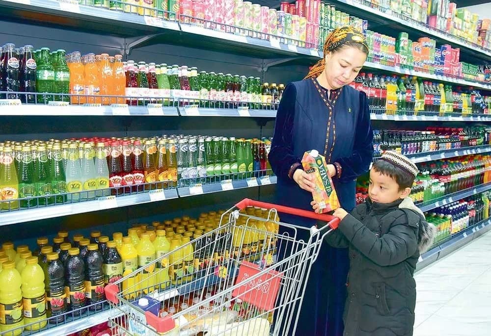 2026-njy ýyl üçin meýilnama: Paýtagtymyzda azyk we azyk däl harytlaryň önümçiligi artar — Türkmenistanyň ýaşaýjylary dükanda söwda etýärler.